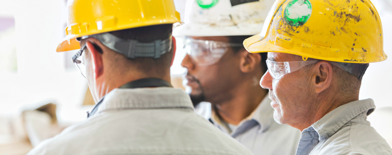 Workers in hard hats at a meeting